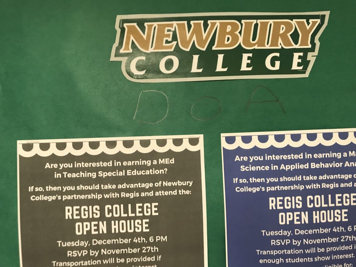 A bulletin board where some student wrote, underneath the name of Newbury College, the letter "DOA."