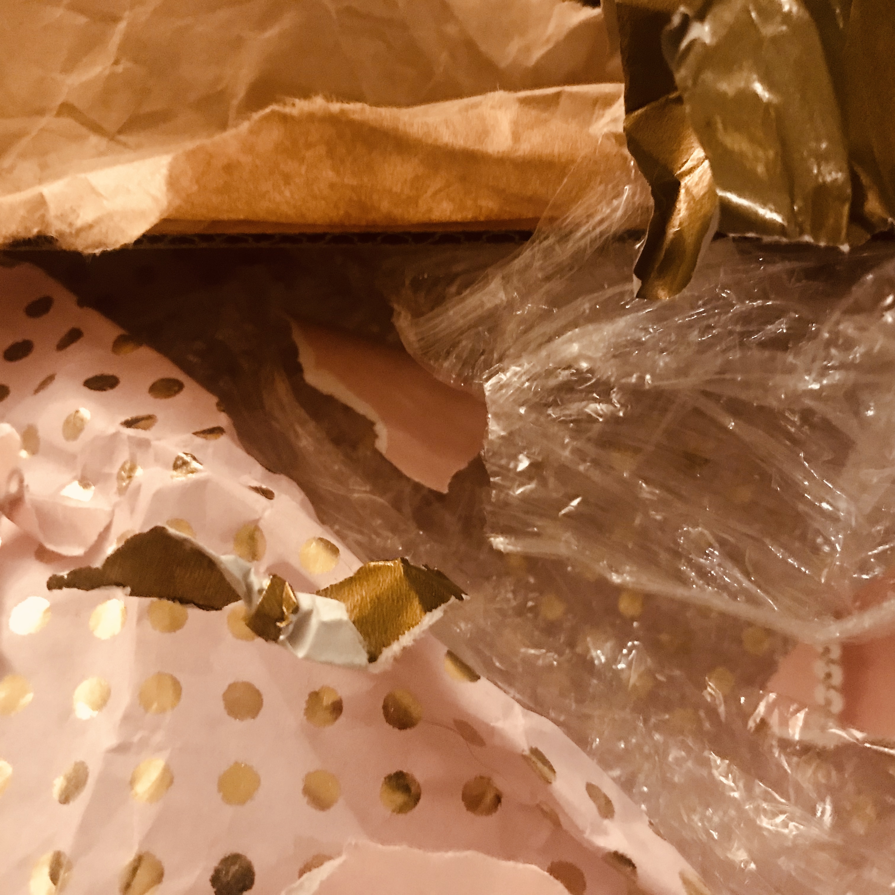(A final image with no text, just wrapping paper, cellophane, and thick brown paper.)